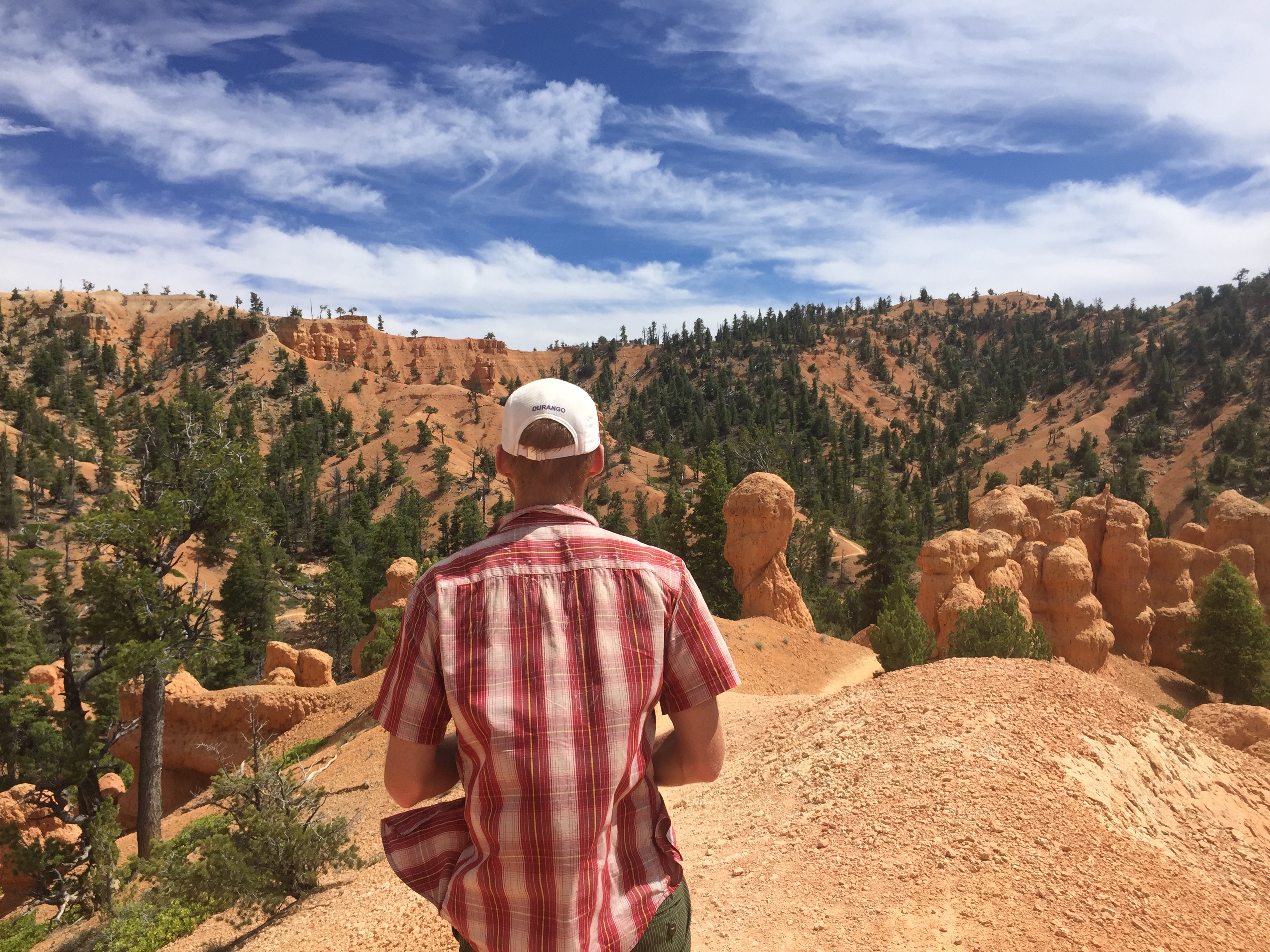 Runner in red plaid going through Bryce Canyon.