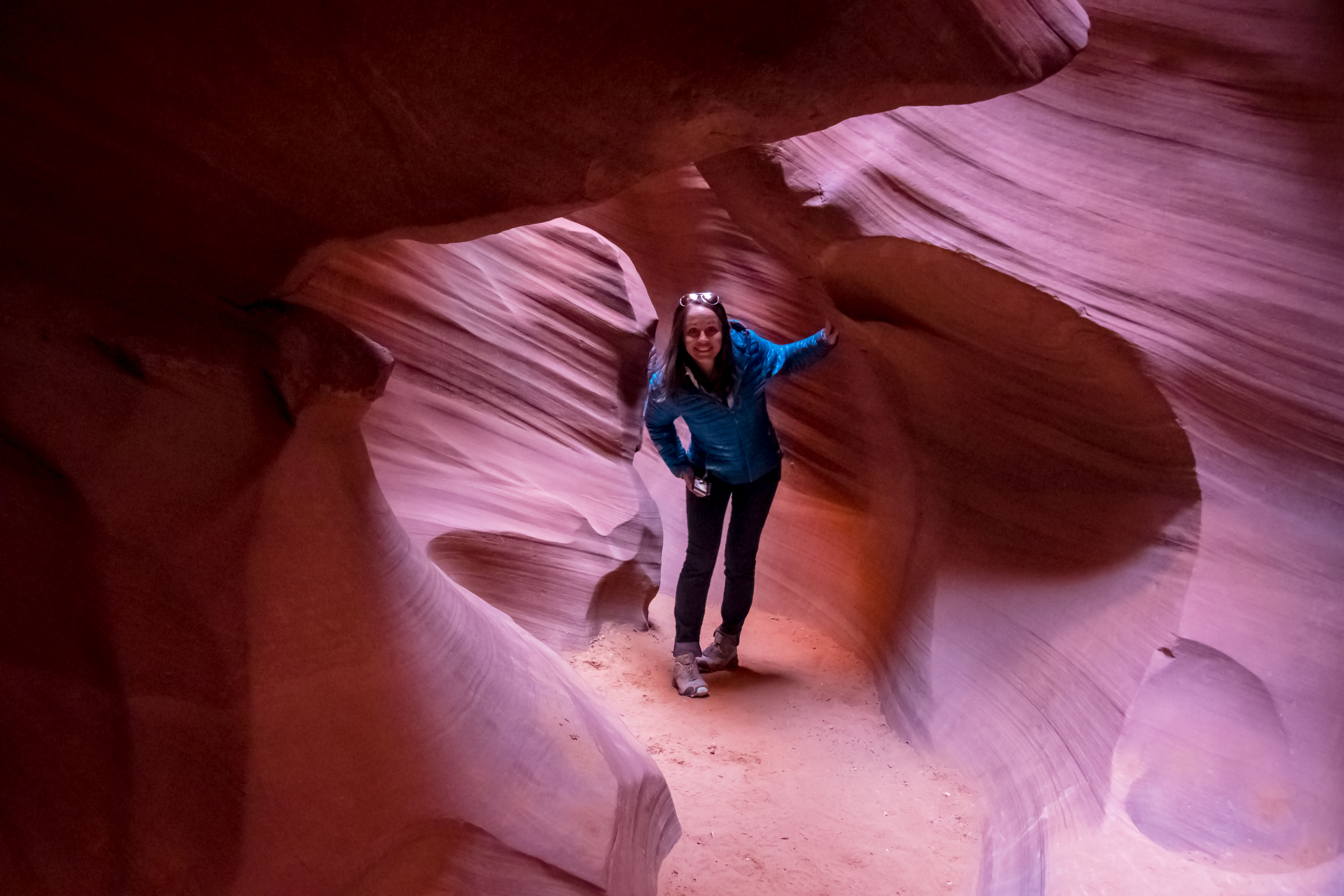 PT traveler peeking through red rock slot canyon