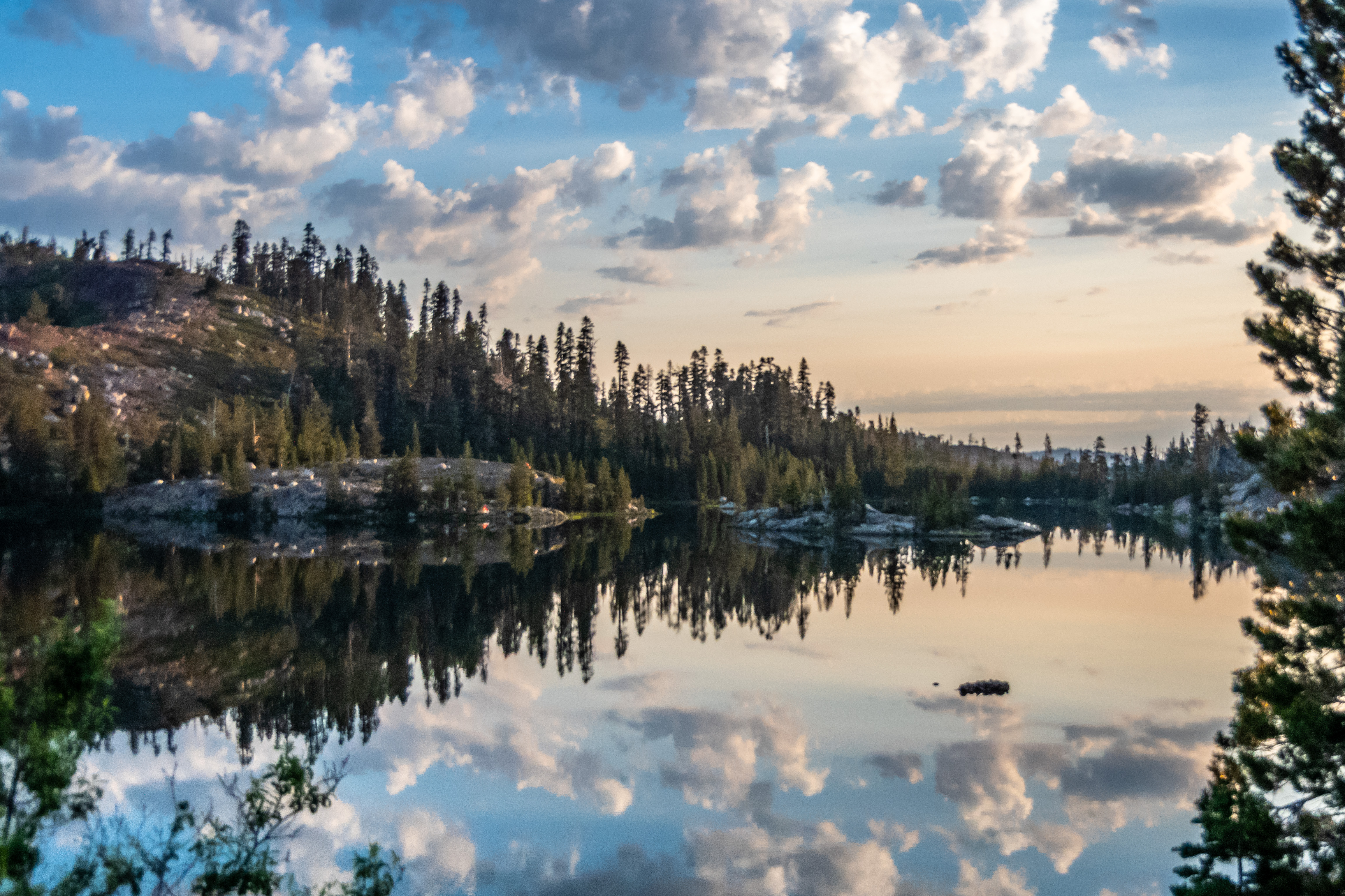 Clouds reflected in alpine lake at sunrise
